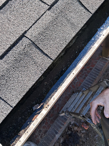 A man working on a roof with a wrench