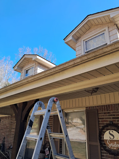 A couple of ladders that are outside of a house